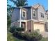 Townhome with a manicured front lawn, two-car garage, and attractive facade at 201 Jonquil Spring Rd, Woodstock, GA 30188