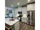 Well-equipped kitchen with white cabinets, stainless steel appliances, quartz countertop, and wood grain flooring at 201 Jonquil Spring Rd, Woodstock, GA 30188