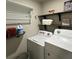 Convenient laundry room featuring a washer, dryer, and rustic wood shelving at 201 Jonquil Spring Rd, Woodstock, GA 30188