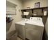 Laundry room area with white washer and dryer, and wooden shelving at 201 Jonquil Spring Rd, Woodstock, GA 30188