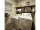 Functional laundry room with washer, dryer, and shelving for ample storage at 201 Jonquil Spring Rd, Woodstock, GA 30188