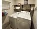 Bright laundry room featuring shelving, front-load white washer and dryer appliances at 201 Jonquil Spring Rd, Woodstock, GA 30188