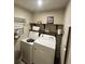 Well-organized laundry room featuring washer, dryer, and shelving at 201 Jonquil Spring Rd, Woodstock, GA 30188