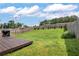 Fenced backyard with a deck, well-manicured lawn, and small evergreen shrubs planted along the back fence line at 3200 Binghampton Ln, Lawrenceville, GA 30044