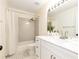 Well-lit bathroom featuring white cabinets, marble countertop and tiled shower and bathtub at 3200 Binghampton Ln, Lawrenceville, GA 30044