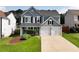 Charming two-story home boasts a manicured lawn and a two-car garage, creating a welcoming curb appeal at 3200 Binghampton Ln, Lawrenceville, GA 30044