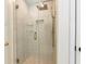 Close up of a glass walk-in shower with gold hardware and a built-in soap niche at 3200 Binghampton Ln, Lawrenceville, GA 30044