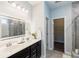 Bright bathroom with double sinks, a soaking tub, a tiled shower, and a walk-in closet at 5440 Wheeler Ridge Rd, Auburn, GA 30011