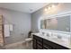 Modern bathroom featuring double vanity, illuminated mirror, gray tile flooring, and a shower, providing a luxurious feel at 5440 Wheeler Ridge Rd, Auburn, GA 30011