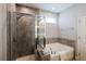 Bathroom with soaking tub, glass shower, and neutral tile plus a bright natural light window at 5440 Wheeler Ridge Rd, Auburn, GA 30011
