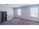 Neutral bedroom featuring gray carpet, two windows, a bookshelf, and natural light, offering versatility and comfort at 5440 Wheeler Ridge Rd, Auburn, GA 30011