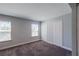 Neutral bedroom featuring gray carpet, two windows, and closet, providing functional storage space at 5440 Wheeler Ridge Rd, Auburn, GA 30011