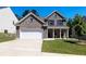 Charming two-story brick home with a well-manicured lawn and a two-car garage at 5440 Wheeler Ridge Rd, Auburn, GA 30011