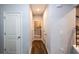Hallway with hard floors leading to laundry room with gray walls and white trim throughout at 5440 Wheeler Ridge Rd, Auburn, GA 30011