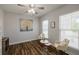 Bright home office featuring a ceiling fan, built-in shelving, and two windows at 5440 Wheeler Ridge Rd, Auburn, GA 30011