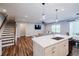 Open concept living space featuring a kitchen island, and staircase with wood railing, plus a tv and couch at 5440 Wheeler Ridge Rd, Auburn, GA 30011
