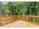 Wide shot of wood back deck with wood railing overlooking a shady, tree-filled backyard at 1111 Pin Oak Dr, Tucker, GA 30084