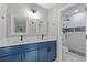 Bathroom with modern blue double vanity, black hardware, and a beautifully tiled shower at 1111 Pin Oak Dr, Tucker, GA 30084