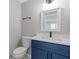 Bathroom featuring a modern blue vanity, black hardware, toilet, and mirror at 1111 Pin Oak Dr, Tucker, GA 30084