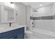 Bathroom with blue vanity and a beautifully tiled tub and shower combination at 1111 Pin Oak Dr, Tucker, GA 30084