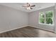 Bedroom with hardwood floors, neutral paint, a ceiling fan, and a window with a backyard view at 1111 Pin Oak Dr, Tucker, GA 30084
