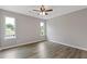 Bedroom with hardwood floors, neutral paint, a ceiling fan, and two bright windows at 1111 Pin Oak Dr, Tucker, GA 30084