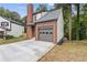 Side view of a charming home boasting an attached garage, brick chimney, and lovely yard at 1111 Pin Oak Dr, Tucker, GA 30084