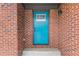 Close-up of a vibrant blue front door with a white-trimmed window inset and brick surround at 1111 Pin Oak Dr, Tucker, GA 30084