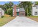 Charming two-story home boasts a brick chimney, attached garage, and vibrant blue front door at 1111 Pin Oak Dr, Tucker, GA 30084