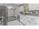 Kitchen with modern appliances, white cabinets, mosaic backsplash, and an eat-in bar at 1111 Pin Oak Dr, Tucker, GA 30084