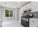 Modern kitchen features stainless steel appliances, white cabinets, and mosaic tile backsplash at 1111 Pin Oak Dr, Tucker, GA 30084