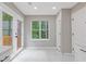 Bright eat-in kitchen area with white cabinets, marble floors, doors to the deck, and a large window overlooking the backyard at 1111 Pin Oak Dr, Tucker, GA 30084