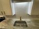 Close-up of a stainless steel kitchen sink with a modern faucet and white subway tile backsplash at 2449 Terrace Trl, Decatur, GA 30035