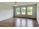 Bright bedroom featuring hardwood floors, neutral walls, a ceiling fan, and abundant natural light from large windows at 3065 Reserve Ct Sw, Conyers, GA 30094
