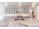 Kitchen island features a marble countertop, sink, faucet, and stylish pendant lighting at 3065 Reserve Ct Sw, Conyers, GA 30094
