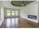 Spacious living room with hardwood floors, tray ceiling, fireplace, and large windows at 3065 Reserve Ct Sw, Conyers, GA 30094