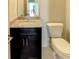 Cozy powder room offers a granite countertop, dark wood cabinet, and modern fixtures at 3065 Reserve Ct Sw, Conyers, GA 30094