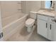 Well-lit bathroom includes a tiled floor, shower-tub combo, white toilet, and vanity with granite countertop at 3292 Mill Forest Dr, Conyers, GA 30094