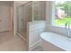 Bathroom with a glass shower, a modern soaking tub, and a window with a view to the outdoors at 3292 Mill Forest Dr, Conyers, GA 30094