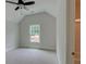 Well-lit bedroom featuring a vaulted ceiling, a ceiling fan, and a window overlooking the lawn at 3292 Mill Forest Dr, Conyers, GA 30094