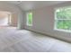 Spacious bedroom with neutral carpet, vaulted ceilings, and multiple windows offering views of the trees at 3292 Mill Forest Dr, Conyers, GA 30094