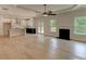 Open-concept living room boasts hardwood floors, a ceiling fan, fireplace, and access to a modern kitchen at 3292 Mill Forest Dr, Conyers, GA 30094