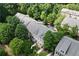 Aerial view of charming townhomes nestled among mature trees, with well-maintained landscaping at 661 Lockton Pl, Sandy Springs, GA 30342