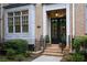 Charming brick home featuring a black front door, wreaths, and manicured landscaping at 661 Lockton Pl, Sandy Springs, GA 30342