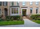Brick townhome showcasing a welcoming front entrance with landscaped shrubs and a sidewalk at 661 Lockton Pl, Sandy Springs, GA 30342