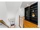 Well-lit hallway with hardwood floors, a wooden banister, and custom built-in shelving at 661 Lockton Pl, Sandy Springs, GA 30342