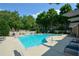 Community pool surrounded by lounge chairs and green trees on a bright day at 661 Lockton Pl, Sandy Springs, GA 30342