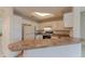 Cozy kitchen with a breakfast bar, white appliances, and view of open living area at 1015 Mcgill Park Ne Ave, Atlanta, GA 30312