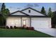 Charming single-story home with white brick, gray trim, lush landscaping, and a two-car garage at 3990 Brushy St, Powder Springs, GA 30127