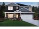 Charming two-story home featuring a stone facade, well-manicured lawn, and an attached two-car garage at 4002 Brushy St, Powder Springs, GA 30127